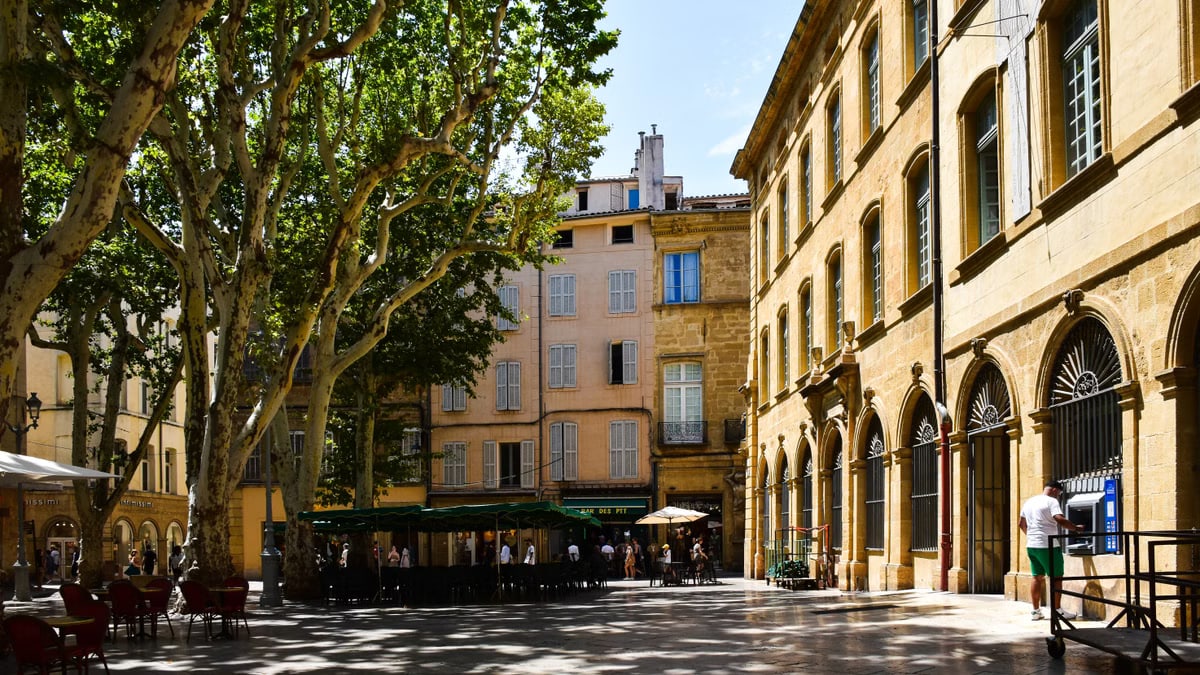 A sunny day in Aix-en-Provence showcasing historic architecture and lush trees.